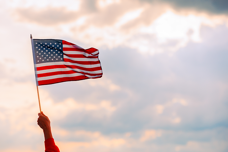 A hand waving the American flag