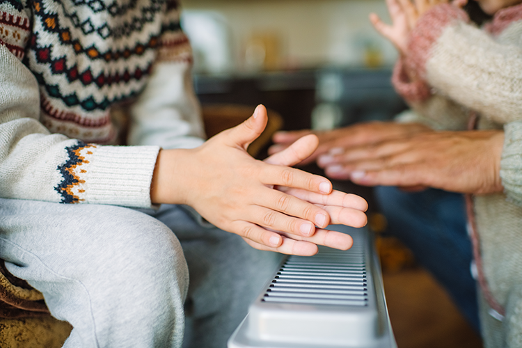 someone warming up their hands with a heater